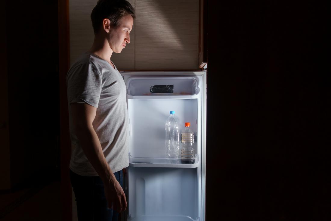 Man looking in a fridge at night
