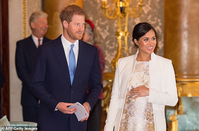 The world is still waiting for news of the birth of Prince Harry and Meghan's first child. They are pictured together at Buckingham Palace on March 5