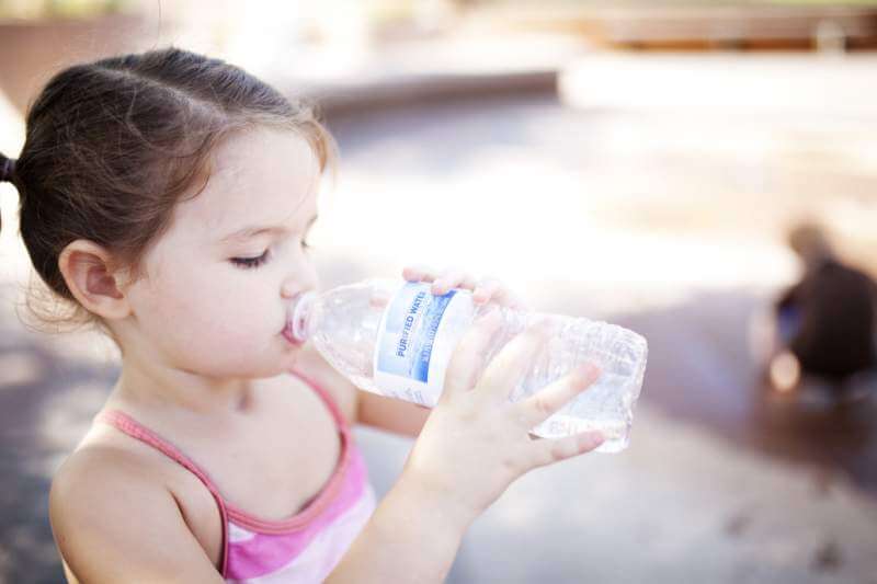 little-girl-drinks-from-a-water-bottle-while-swimming