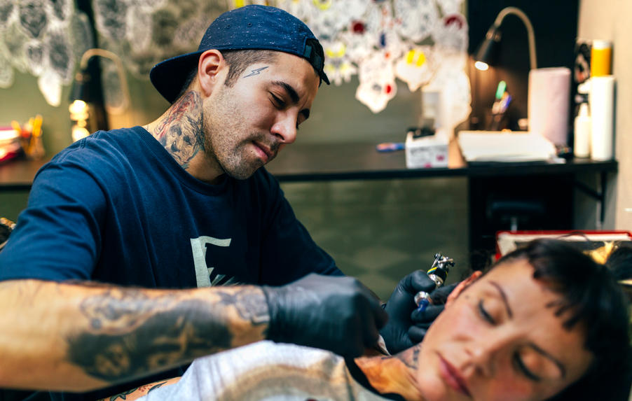 tattoo artist applies a tattoo