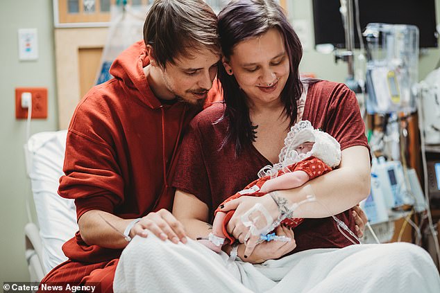 Krysta Davis  continued with her pregnancy knowing her baby would not survive. The assistant manager is pictured with her partner Derek Lovett moments after their daughter Rylei Arcadia was born. She arrived with parts of her brain and skull missing, and lived just a week