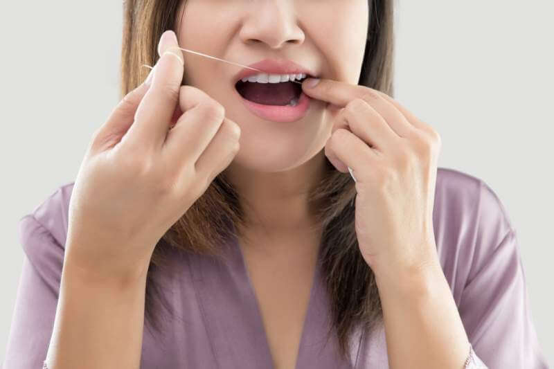 woman-flossing-teeth-with-dental-floss