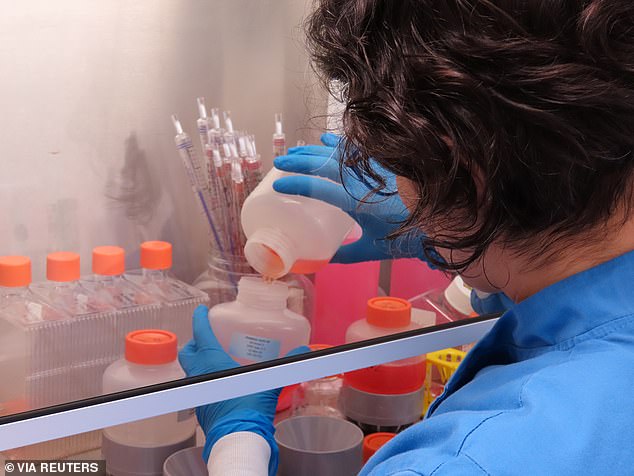 A scientist working on the team developing the ChAdOx1 vaccine candidate against COVID-19 pouring fluids at the Clinical Biomanufacturing Facility (CBF) in Oxford