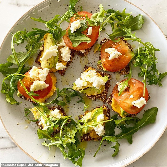 Nutritionist Jessica Sepel said Olina seed crackers topped with Yumi's pumpkin hummus, avocado, goats cheese, tomatoes and rocket is an easy and delicious meal to prepare (pictured)