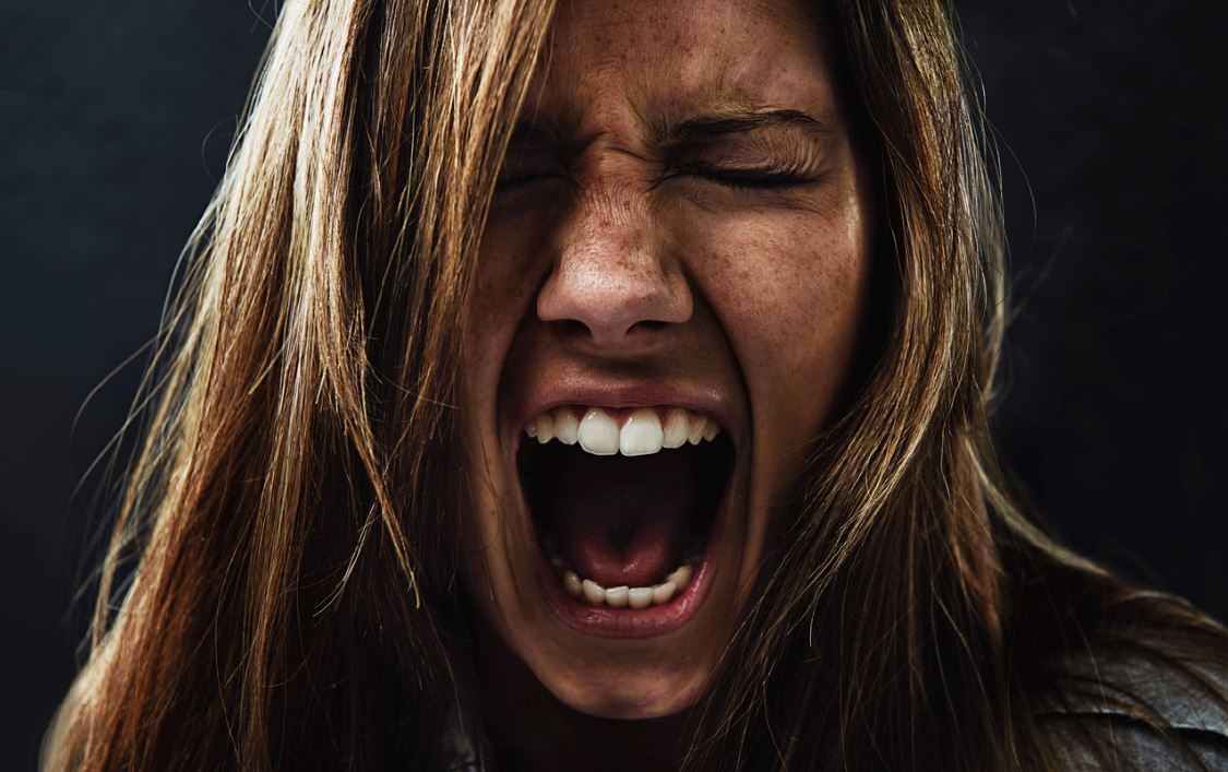 stressed woman migraine symptoms