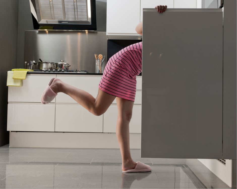 woman in her fridge looking for a snack bad habits