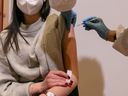 A young woman is vaccinated with the Pfizer-BioNTech vaccine on March 11, 2021 in Schwaz, Austria.